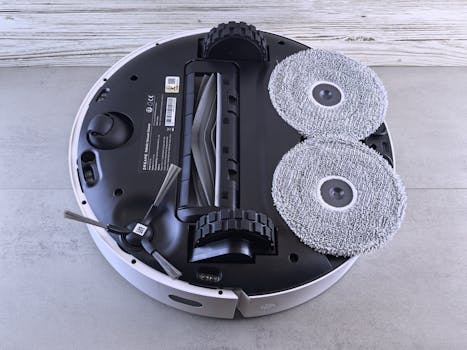 Detailed view of a robotic vacuum cleaner's underside showing brushes and wheels.
