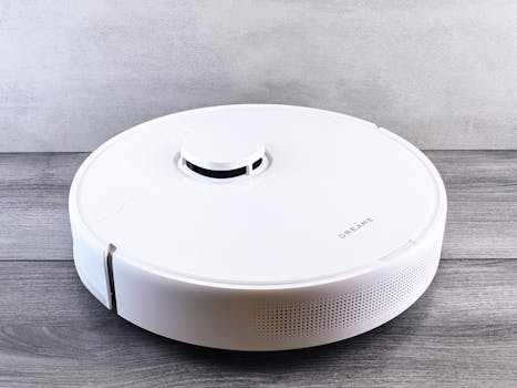 Sleek white robot vacuum cleaner on a wooden floor, perfect for smart home setups.